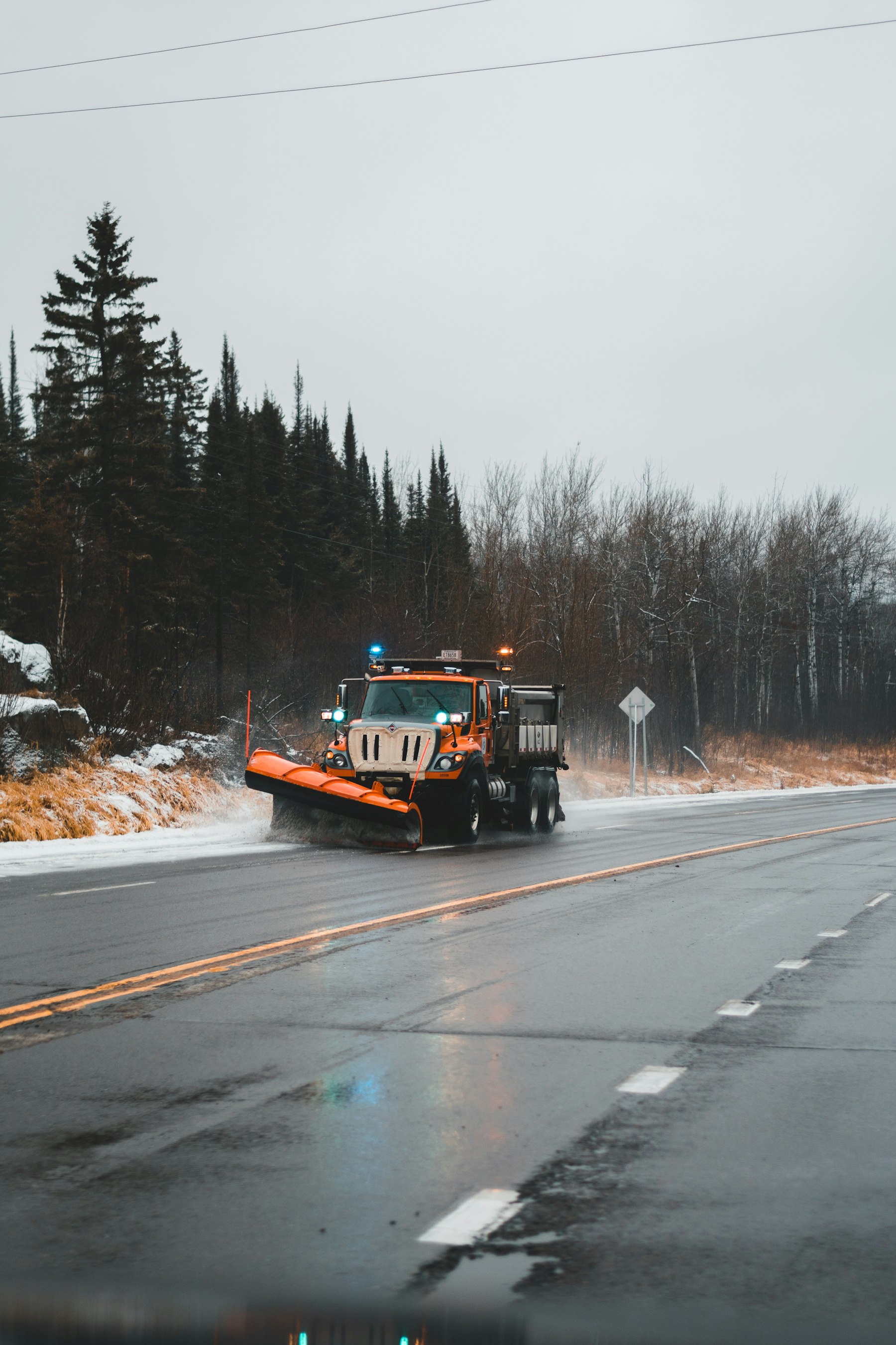 Snowplow truck clearing a driveway at first light in Central New York